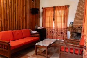a living room with a red couch and a fireplace at Cabañas Sierra Verde in Cedro
