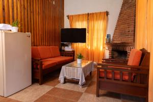 a living room with a couch and a television at Cabañas Sierra Verde in Cedro