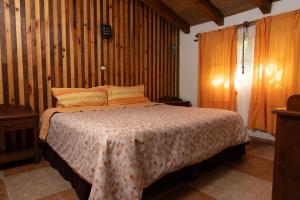 a bedroom with a bed with a wooden wall at Cabañas Sierra Verde in Cedro