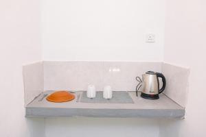 a counter with a coffee maker and a kettle on it at Lazy Monkey Green Chalets in Hiriketiya