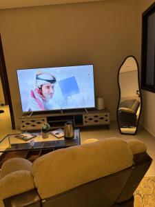 a living room with a couch and a flat screen tv at فنادق مخدومة in Quai