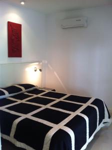 um quarto com um edredão preto e branco numa cama em Departamento Green Park em Punta del Este