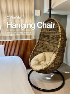 a rattan hanging chair in a bedroom with a bed at suite Funabashi LAGOON1 #101 in Funabashi