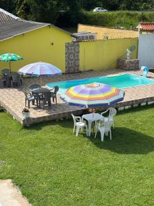 a patio with tables and umbrellas next to a pool at Pousada Sol e Mar Dias Cezar in Paraty +18 photos