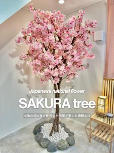 a cherry tree mural in a room with a chair at suite Funabashi SAKURA1 #102 in Funabashi