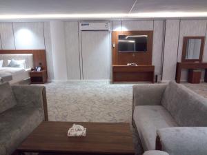 a hotel room with two couches and a bed at ﻣﺆﺳﺴﺔ ﺷﻘﻖ ﺍﻟﻘﺎﺭﺍﺕ ﺍﻟﺴﺒﻊ ﺍﻟﻤﺨﺪﻭﻣﺔ in Raḩīmah