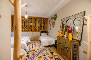 a bedroom with two beds and a mirror at Riad dreams imlil in Imlil