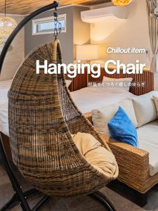 a hanging rattan chair sitting next to a bed at suite Funabashi LAGOON2 #201 in Funabashi