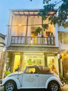 an old white car parked in front of a building at Ayubowan Home in Galle