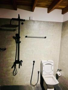 a bathroom with a toilet and a camera on the wall at Ayubowan Home in Galle