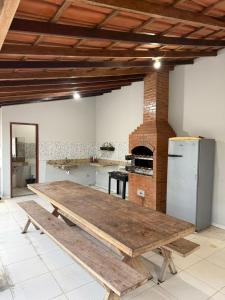 a kitchen with a wooden table and a refrigerator at Casa Guriri in São Mateus