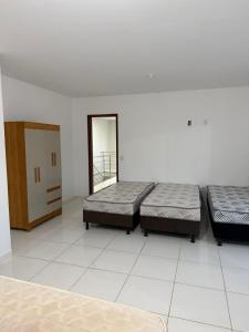 a room with two beds and a mirror at Casa Guriri in São Mateus