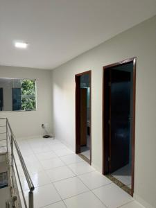 a hallway with two doors and a tile floor at Casa Guriri in São Mateus