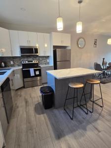 a kitchen with a counter and two bar stools at The Lots home in Winnipeg