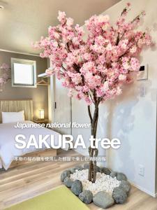 a tree with pink flowers in a bedroom at suite Funabashi SAKURA2 #202 in Funabashi