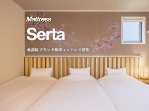 two beds in a room with a serta sign on the wall at suite Funabashi SAKURA2 #202 in Funabashi