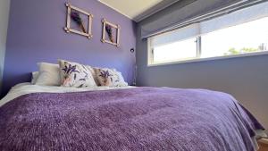 a purple bedroom with a bed and a window at Lavanda del Valle in Vicuña