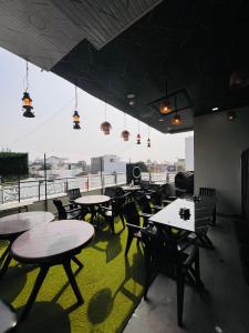 a restaurant with tables and chairs and a large window at Hotel Basil Inn in Ujjain
