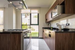 a kitchen with wooden cabinets and a large window at Private Room w/ Ensuite Bath & top Amenities in La Cañada