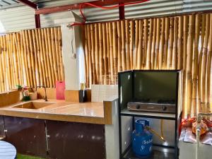 a kitchen with a television and a counter with a sink at Rustic Retreat room only in San Fernando