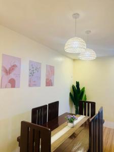 a dining room with a table and chairs and paintings at Homestay in Lipa City in Lipa