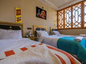 a bedroom with two beds and a window at Riad dreams imlil in Imlil +4 photos