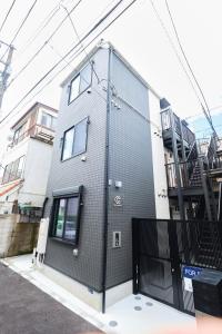 a gray building with a black fence in front of it at Le Cocon Nakarokugo by Tranova in Tokyo +15 photos