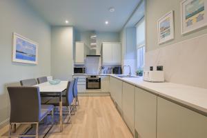 a kitchen with a table and chairs and a counter at Gordon's Getaway Lux in Oban