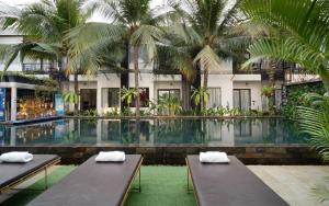 a swimming pool with two benches in front of a building at Central Corner d'Angkor in Siem Reap +137 photos
