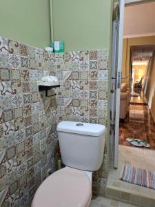 a bathroom with a toilet and tiles on the wall at ParabonHaus Kopitiam - Bed & Breakfast in Gegarbensang +46 photos