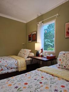 a bedroom with two beds and a window at ParabonHaus Kopitiam - Bed & Breakfast in Gegarbensang