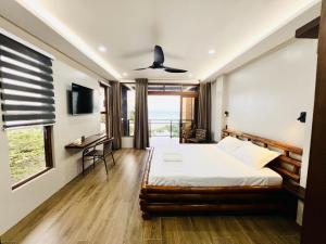 ein Schlafzimmer mit Bett, Schreibtisch und Fenster in der Unterkunft Seajour Beach Resort in Ginatilan