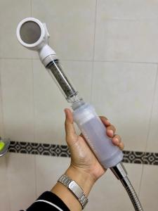 a person holding a blow dryer in a bathroom at Baguio BELL Staycation in Baguio