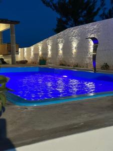 a blue swimming pool in a yard at night at Casa brisa do mar icapuí in Icapuí