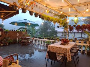 a patio with tables and chairs and an umbrella at ParabonHaus Kopitiam - Bed & Breakfast in Gegarbensang
