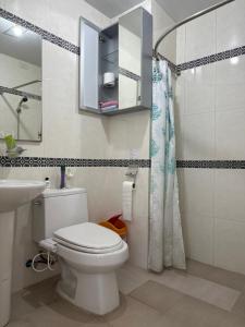 a bathroom with a toilet and a sink and a shower at Baguio BELL Staycation in Baguio +114 photos