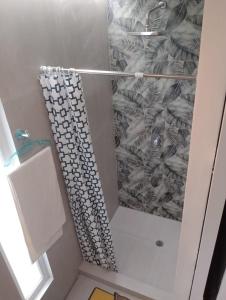a shower with a shower curtain in a bathroom at Psi Nova in Baños