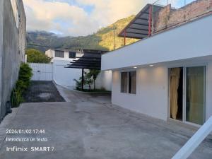 an empty driveway next to a house with a fence at Psi Nova in Baños