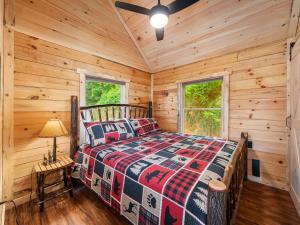 a bedroom with a bed in a log cabin at The Three Dog Night Cabin in Bryson City
