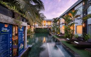 a hotel with a swimming pool in front of a building at Central Corner Suite in Siem Reap