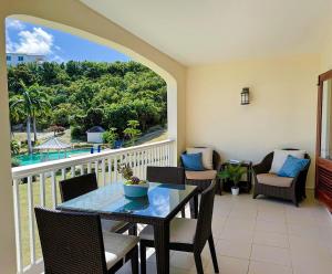 a balcony with a table and chairs on a balcony at Breathtaking Views Private 1 Bed Villa in Freetown Village +12 photos