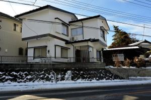 a white house on the side of a street at APROSTAY Fuji-kawaguchiko Aizen15 in Fujiyoshida