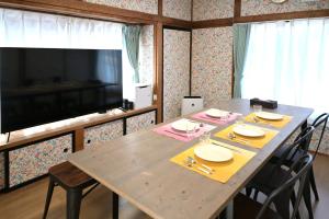 a dining room with a table with chairs and a television at APROSTAY Fuji-kawaguchiko Aizen15 in Fujiyoshida