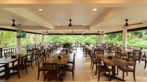 a dining room with tables and chairs and windows at Mae Jo Golf Resort & Spa in San Sai