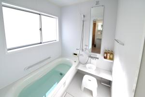 a bathroom with a bath tub and a window at APROSTAY Fuji-kawaguchiko Aizen15 in Fujiyoshida +46 photos