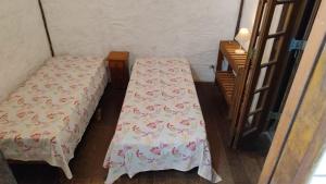 two beds in a room with a table at Suite casa cachoeira in Paraty