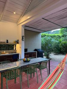 a patio with a table and chairs and a hammock at Juntas del Lago - Casa 2 in Apulo