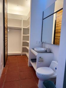 a bathroom with a toilet and a sink at Juntas del Lago - Casa 2 in Apulo