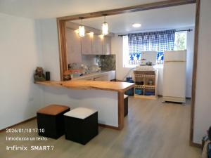 a kitchen with a wooden table and a refrigerator at Psi Nova in Baños +14 photos
