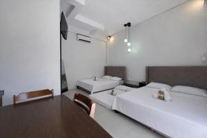 a room with two beds and a table and chairs at Sundown Lodge in San Fernando